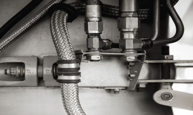 Close-up view of industrial hydraulic or pneumatic hoses and metal fittings.
